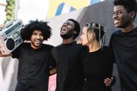 Happy group of multiracial people having fun listening music wit